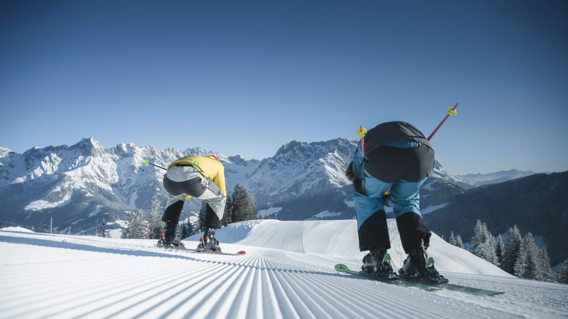 Skifahren - 2 Personen fahren die Piste runter